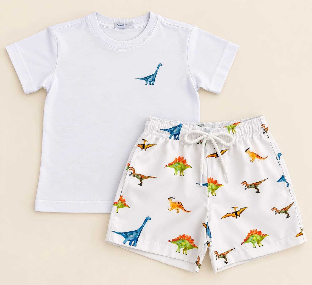 Conjunto Camiseta e Shorts Básico — Dinossauros — Camiseta branca com desenho de dinossauro e shorts com estampa de dinossauros coloridos