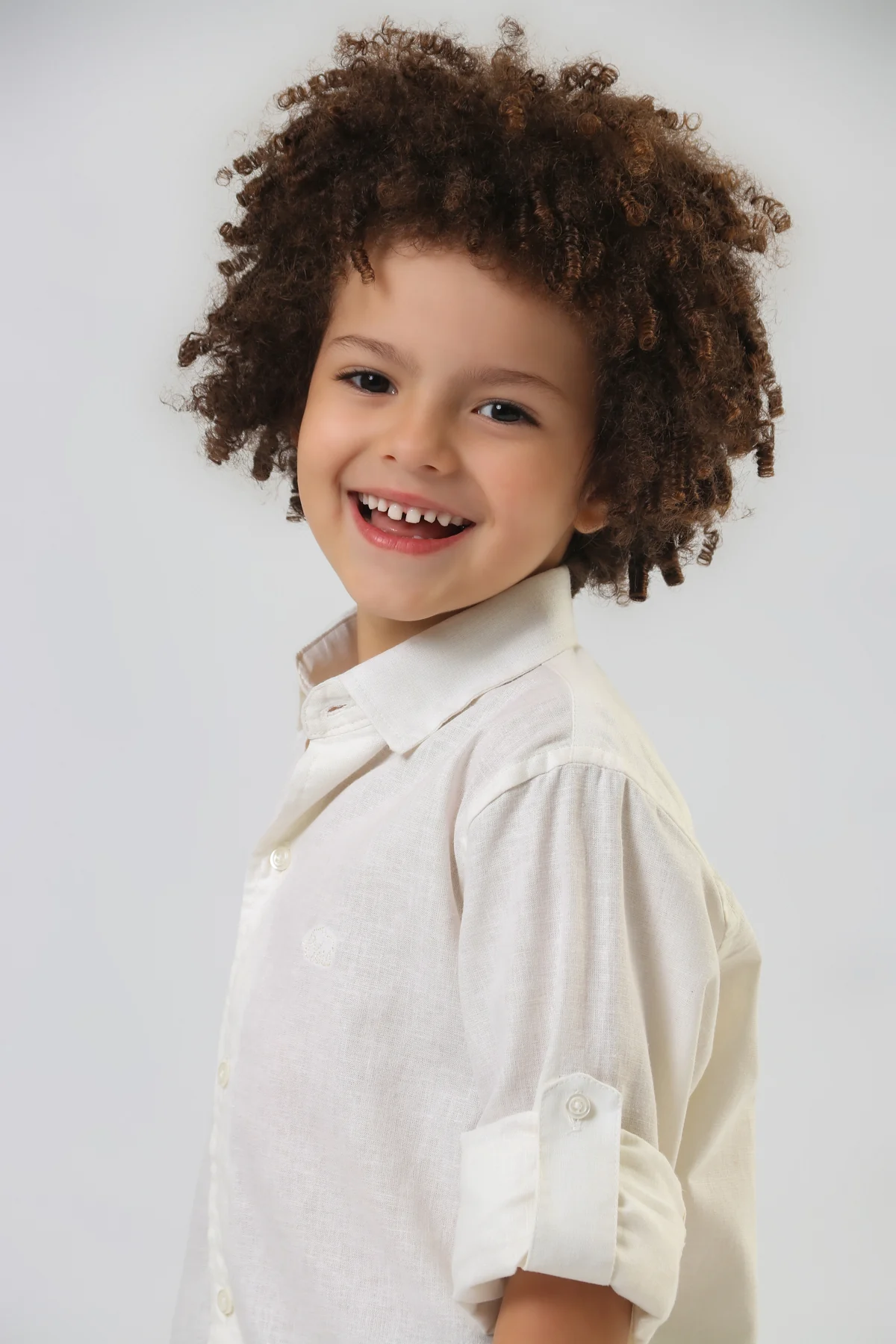 Camisa clara com gola e mangas dobradas, em retrato da coleção
